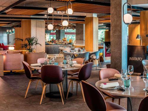 マドリードにあるIbis Styles Madrid City Las Ventasのテーブルと椅子とバーのあるレストラン