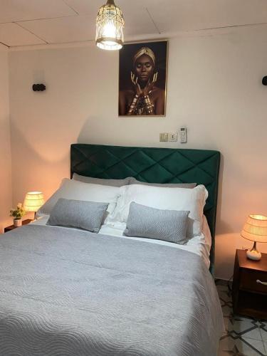 una camera da letto con un letto grande con testiera verde di I&J Resort VIP a Yaoundé