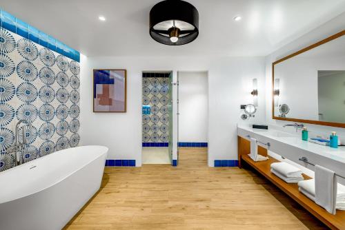 Ocean Allure Costa Mujeres - Adults Only - All Inclusive في Costa Mujeres: حمام مزود بحوض استحمام ومغسلة ومرآة