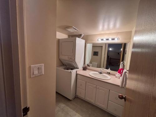 Horsethief Lodge by StayIn في بانوراما: حمام صغير مع حوض وثلاجة