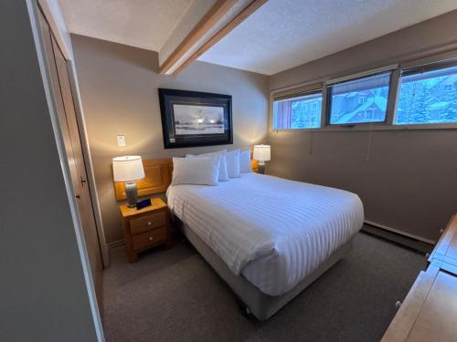 Horsethief Lodge by StayIn في بانوراما: غرفة نوم بسرير ابيض ونوافذ