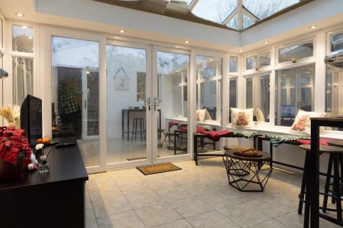 a conservatory with windows and a living room at Modern 4-bed home Royal Wharf near Excel Canary Wharf London city airport The O2 -Free parking in North Woolwich