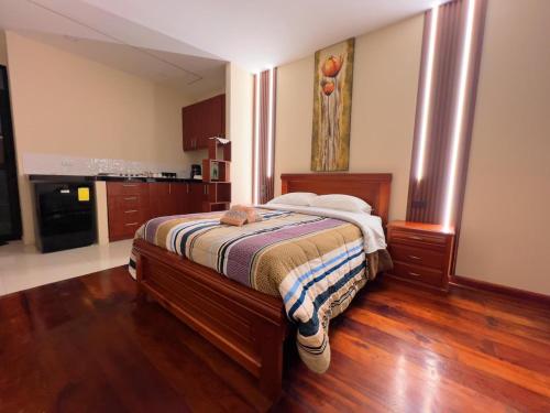 una camera con letto e pavimento in legno di Estreno Suite en Loja, Valle a Loja