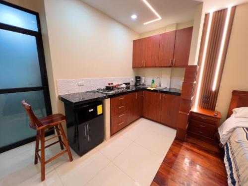 una cucina con mobili in legno e un piano di lavoro di Estreno Suite en Loja, Valle a Loja