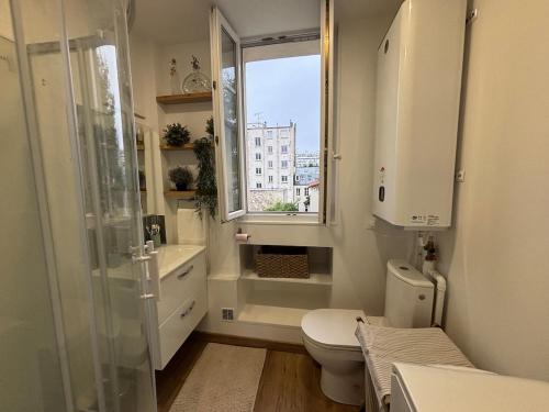 a bathroom with a shower and a toilet and a window at Charmant studio - Vanves in Vanves