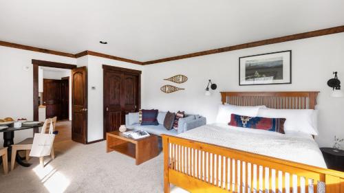 a bedroom with a bed and a couch at Bighorn by AvantStay Spacious Ski Cabin w Sprawling Porch Views Hot Tub in Vail