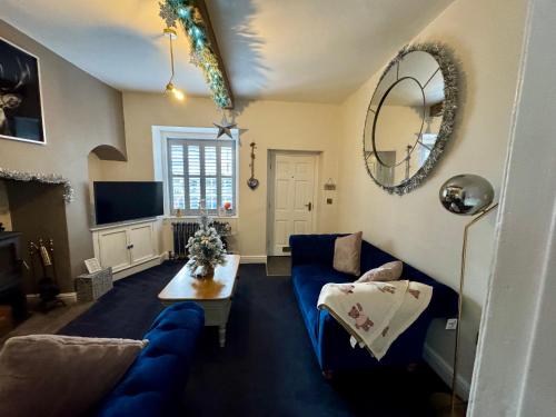 a living room with a blue couch and a table at Castle Yard Cottage in Knaresborough