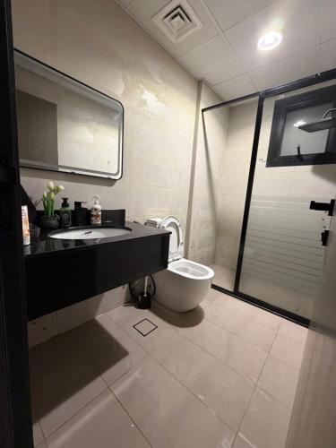 a bathroom with a toilet and a sink and a shower at Sh vellage in Sharjah