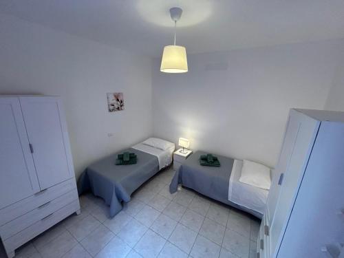 a small room with two beds and a light at Il nido di Fra&Gab in Genova