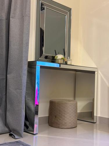 a mirrored table with a stool and a mirror at Sh vellage in Sharjah