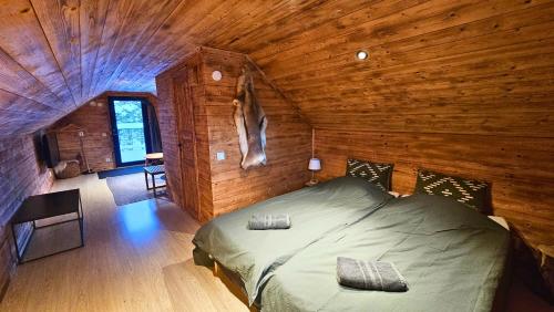 Cozy River Cabin Styled Loft في كيرونا: غرفة نوم مع سرير في كابينة خشبية