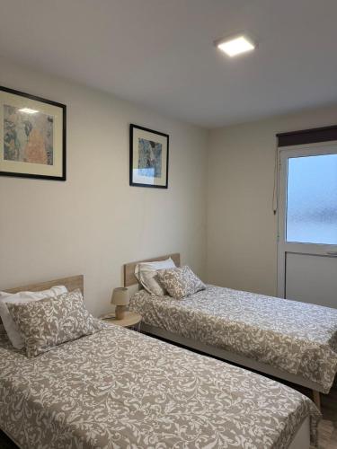 a bedroom with two beds and a window at Casa da Boa Ventura in Vila Franca do Campo