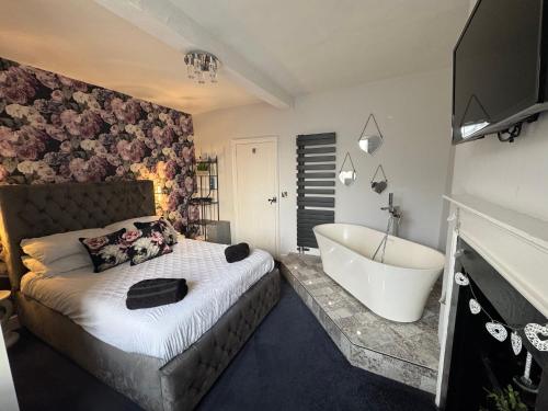 una camera da letto con un letto grande e una vasca da bagno di Castle Yard Cottage a Knaresborough