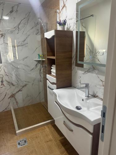 Monte Village في نيكشيتش: حمام أبيض مع حوض ومرآة