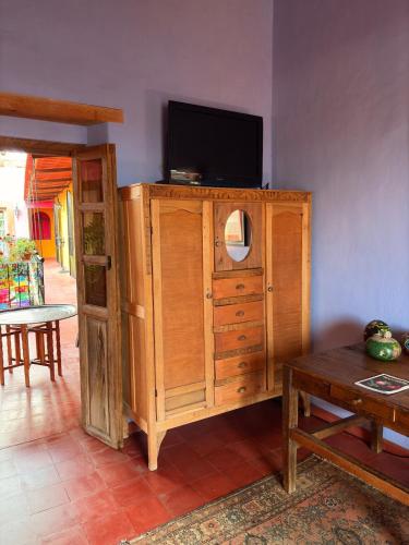 a wooden cabinet with a television on top of it at Posada de la cruz#1 in Querétaro