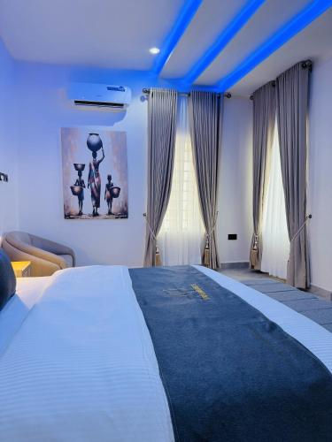 a bedroom with a large white bed with blue ceilings at StayatMargarets in Abuja