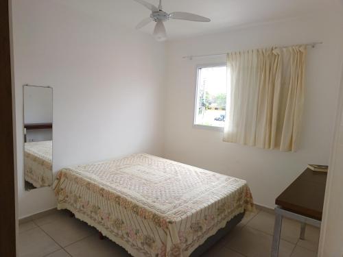 a bedroom with two beds and a window at Apartamento superior Boracéia in Bertioga
