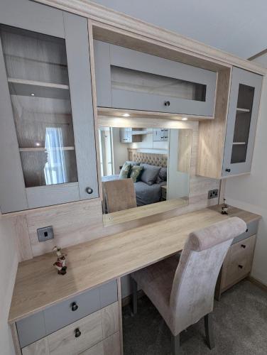 a desk with a mirror in a room at ABI Beaumont Luxury Caravan, Steps from Durdle Door in West Lulworth