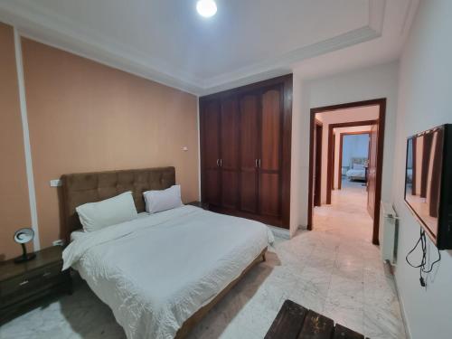 a bedroom with a bed and a flat screen tv at Appartement de luxe lac 2 in Tunis