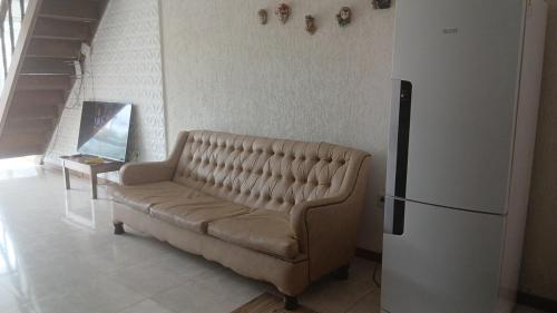a living room with a couch and a refrigerator at Quartos em Arraial do Cabo in Arraial do Cabo