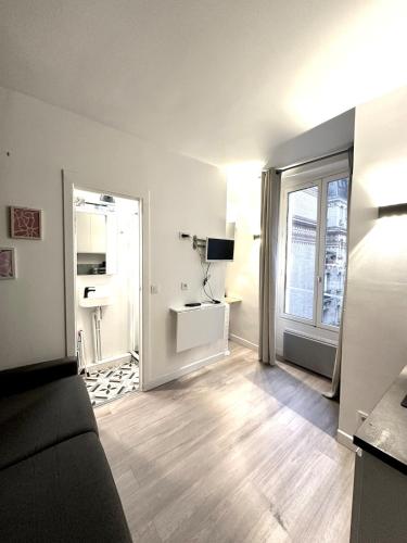 een woonkamer met een bank en een raam bij Charming Studio - Trail in La Celle-sous-Gouzon