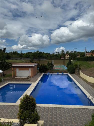 a large pool with blue water in a yard at Joy's Home Rental in Tagbilaran City