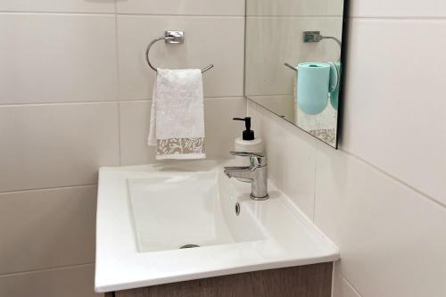 een badkamer met een witte wastafel en een spiegel bij Incredible apartment, front beach la horseshoe 