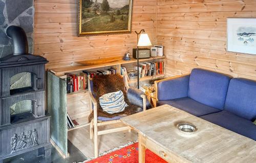 a living room with a blue couch and a stove at Awesome Home In Tjørhom in Haugen