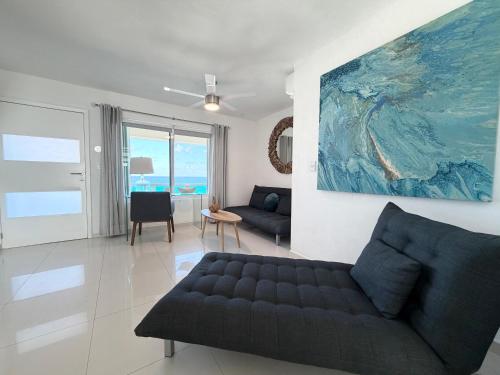 a living room with a couch and a painting on the wall at Beachfront Three-Story Coastal Penthouse, 3BR-3BA in Cancún