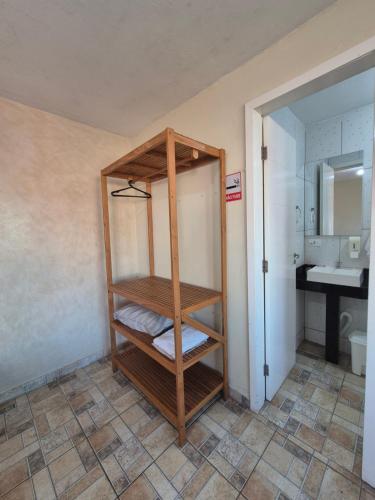 イタポアにあるHotel Recanto das Pedrasのバスルーム(木製の棚付)