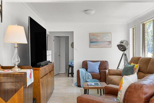 ein Wohnzimmer mit Sofa und Flachbildfernseher in der Unterkunft Sunny Days Villa Vincentia in Vincentia