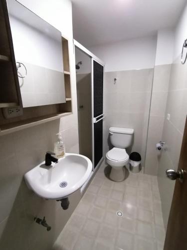 a white bathroom with a sink and a toilet at Tu Loft Ideal Amoblado, Wifi, Parqueadero y Confort in Bucaramanga