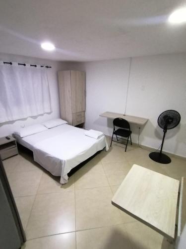 a bedroom with a bed and a desk and a chair at Tu Loft Ideal Amoblado, Wifi, Parqueadero y Confort in Bucaramanga