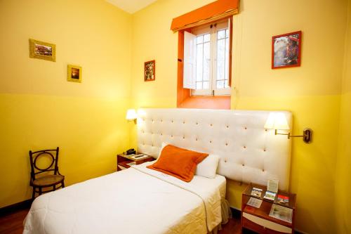 a bedroom with a white bed and a window at Lima Wari Hotel Boutique in Lima