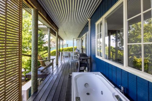 ein Badezimmer mit einer Badewanne auf einer Holzterrasse in der Unterkunft The Garden Room by Waiheke Pure in Waiheke Island