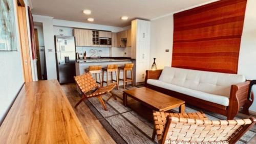 un salon avec un canapé et des chaises et une cuisine dans l'établissement Hermosa vista frente al puerto de Iquique, à Iquique