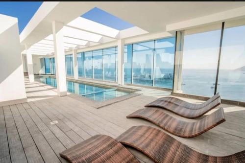 - un balcon avec des chaises et une piscine dans un bâtiment dans l'établissement Hermosa vista frente al puerto de Iquique, à Iquique