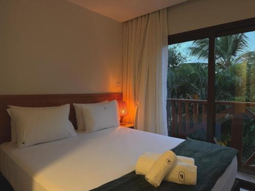 una camera da letto con un letto grande con una finestra di Villa Bougainville 01 - Natú a Mata de Sao Joao