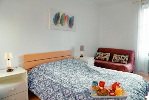 ein Schlafzimmer mit einem Bett, auf dem ein Tablett mit Essen steht in der Unterkunft La Tanière du Corsaire - Coliving - jusqu'à 4 chambres - vue Rivière in Redon