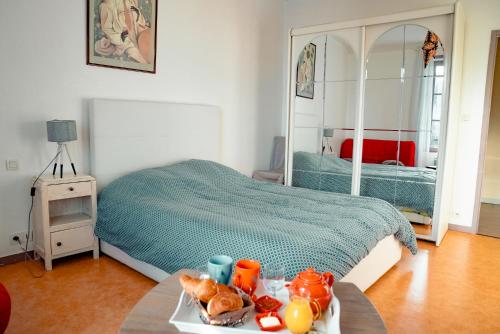 ein Schlafzimmer mit einem Bett und einem Tablett mit Essen auf einem Tisch in der Unterkunft La Tanière du Corsaire - Coliving - jusqu'à 4 chambres - vue Rivière in Redon