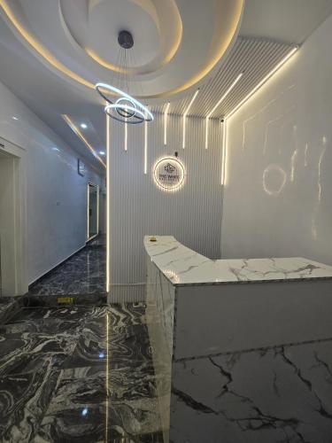 a lobby with a marble counter and a ceiling at The White Residence, Jabi, Abuja in Abuja