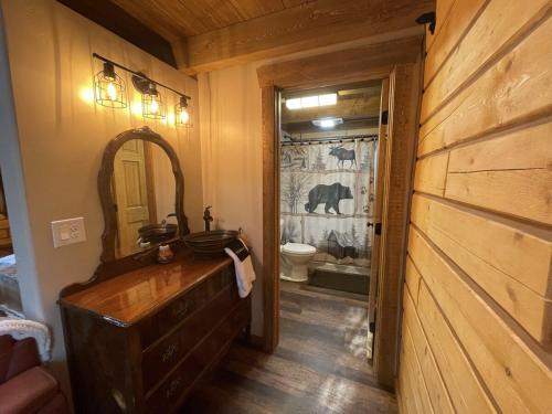 Riverfront, Authentic, Luxury Log Cabin-Bison في واسيلا: حمام مزود بحوض ومِرآة
