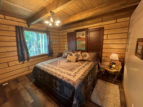 Riverfront, Authentic, Luxury Log Cabin-Bison في واسيلا: غرفة نوم مع سرير في كوخ خشبي