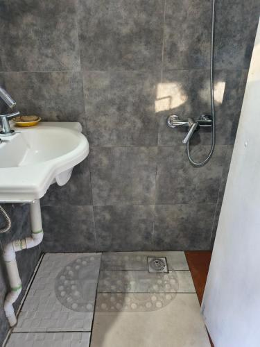 a bathroom with a sink and a shower at Refugio CASA NAVE Torre del Bosque in San Eduardo del Mar