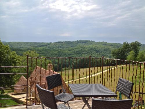 Ein Tisch und Stühle auf einem Balkon mit Aussicht in der Unterkunft Maison Milou in Beynac-et-Cazenac