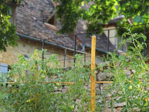 einem Holzzaun vor einem Gebäude in der Unterkunft Maison Milou in Beynac-et-Cazenac