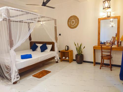 a bedroom with a bed with a mosquito net at Mountain Relax Inn in Weligama