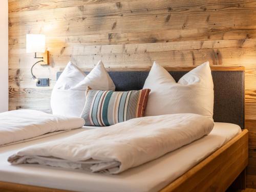 two pillows on a bed with a wooden wall at Hopfgarten Alpin Living Top 6 in Hopfgarten im Brixental