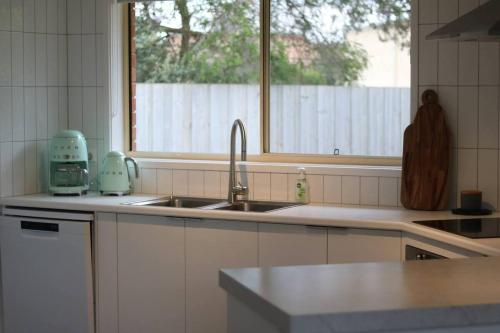 a kitchen with a sink and a window at Senja in Torquay