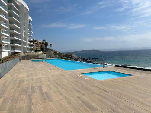 Departamento Familiar Premium Vista Mar Playa Blanca في Playa Blanca: مسبح فوق مبنى بجانب المحيط